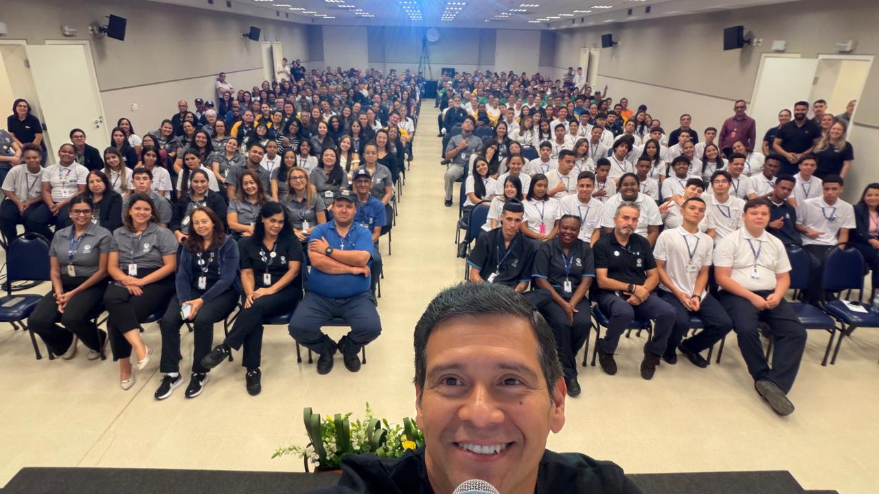 Cristiano Franco com microfone diante de um auditório com participantes